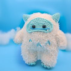 a white stuffed animal with blue eyes on a blue background