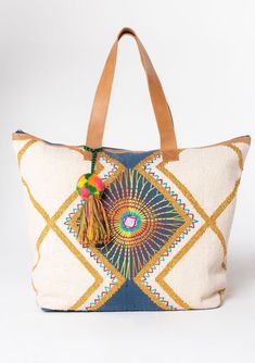 A bag worthy of a vacation! This bohemian oversize weekender bag features a colorful embroidered sunburst detail and suede leather trim. The large carry-all size is perfect for weekend getaways.   Embroidered Stitch details Oversize tassel accent Zip-top closure  Back exterior zip pocket Leather strap handles Bohemian weekender bag Dimensions: 24" X 17 3/4"Style: DR-8369 Carpet Bags, Boho Travel, Boho Tote Bag, Boho Tote, Weekend Travel Bags, Colorful Embroidery, Bohemian Bags, Carpet Bag, Chic Bags