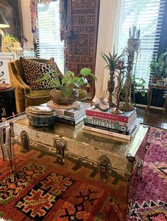 a living room filled with lots of furniture and books on top of a coffee table