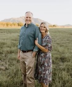 a man and woman standing in the middle of a field