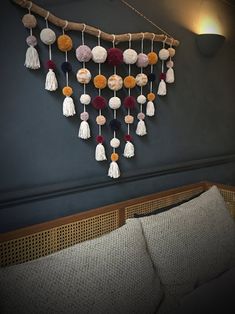 a wall hanging with tassels and pom - poms on the side