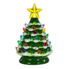 a green glass christmas tree with gold star on top and multi colored ornaments around the base