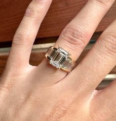 a woman's hand with a ring on it and two baguettes in the middle