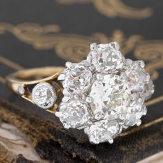 an antique diamond cluster ring on top of a book