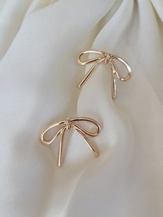 Add a touch of whimsy to your wardrobe with these stylish bow earrings. The perfect mix of classic elegance and modern charm, these earrings are sure to elevate your style. Embrace simplicity and sophistication with the playful design of these must-have accessories. Product details: length: 1" width: .75" earring back: Post metal finish: Gold Plating anti-tarnish: Double E-coating Bow Earring, Post Metal, Coquette Bow, Bow Earrings, Earring Backs, Playful Design, Classic Elegance, Piercings, Gold Plate