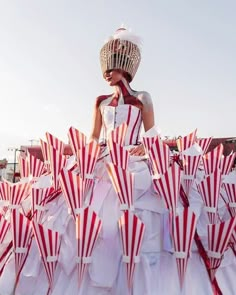 a woman in a white and red dress with lots of umbrellas