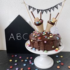 a cake with chocolate frosting and sprinkles on top sitting on a table