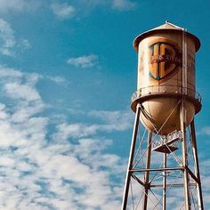 an old water tower with the word tcp painted on it's side against a blue sky