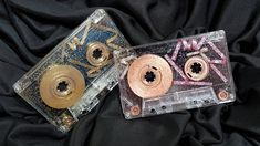 two cassette tapes with gold and pink sprinkles on them sitting next to each other