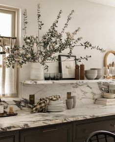 a kitchen counter topped with plates and cups