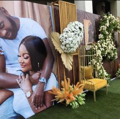 a couple's photo is placed on the side of a wall with flowers in front of it