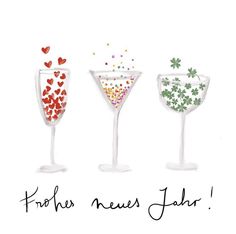 three martini glasses filled with confetti and sprinkles on white background