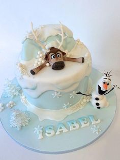 a frosted cake with a dog and snowman on it