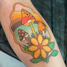 a colorful tattoo with mushrooms and flowers on the arm, in front of a green background