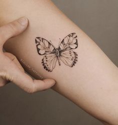 a woman's arm with a butterfly tattoo on the left side of her arm