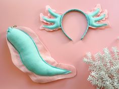 a pair of shoes with wings on them next to a plant and other items that are made out of felt