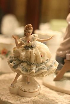 a figurine sitting on top of a table next to some cups and saucers