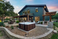 a large hot tub sitting in the middle of a gravel area next to a house