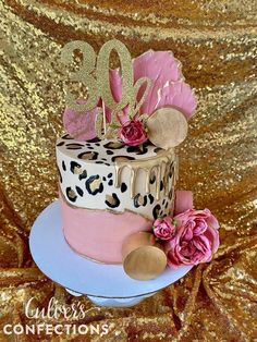 a cake decorated with leopard print and pink flowers