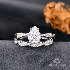 a white gold ring with a pear shaped diamond in the center