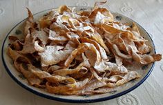 a plate full of potato chips covered in powdered sugar on top of a table