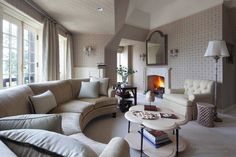 a living room filled with furniture and a fire place in the middle of it's walls