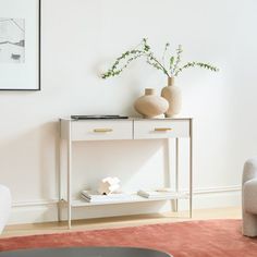 a table with two vases on top of it next to a couch and chair