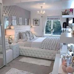 a bedroom with white furniture and chandelier