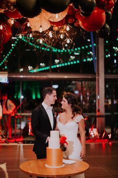 a newly married couple standing in front of a cake