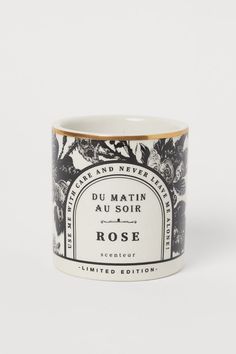 a black and white mug with the words rose printed on it in gold trimming