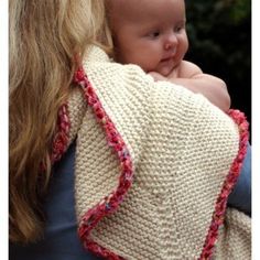 a woman holding a baby wrapped in a blanket