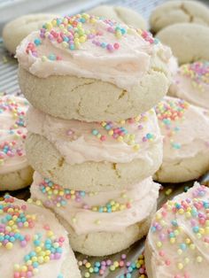 a pile of cookies with frosting and sprinkles