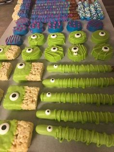 there are many green and blue treats on the table with googly eyes in them