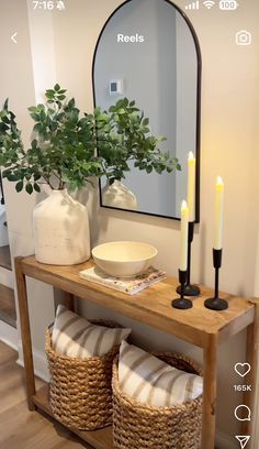 a wooden table topped with a mirror next to a plant