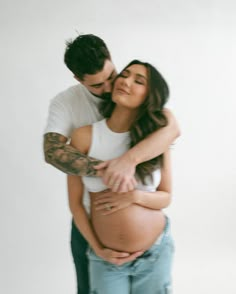 a pregnant woman is holding her husband's belly