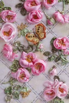 some pink flowers and butterflies on a white table cloth with green leaves around the edges