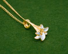 The lily is an iconic flower synonymous with summer. The gentle curves and subtle finish of this flower design gives this series an elegant and timeless look. With a base of high purity silver and plated with 23K Gold, the gold has been partially scraped away to reveal the silver underneath. The Silver-only version has also been partially scraped to create the contrast in textures. Pendant length: approximately 21mm Chain length: 40cm (15.8 in), 45cm (17.7 in) or 50cm (19.7 in) Pendant material: Gold Necklace Set Design, Diamond Necklace Set Indian, Lilly Necklace, Japanese Pendant, Small Diamond Necklace, Small Gold Necklace, Lily Jewelry, Necklace Tattoo, Lily Necklace