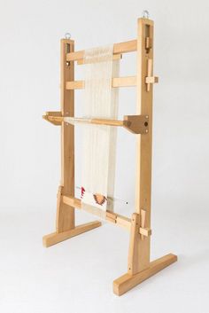 a small wooden weaving machine on a white background