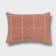 an orange and white checkered pillow on a gray background