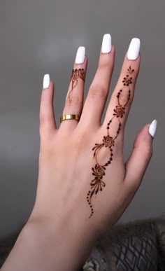 a woman's hand with henna tattoos on it