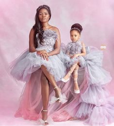 two women in dresses posing for a photo with one holding the other's leg