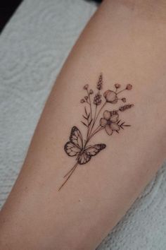 a small butterfly and flower tattoo on the arm