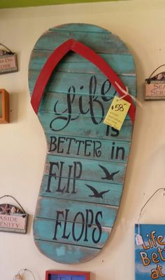 there is a sign that says life is better in flip flops on the wall