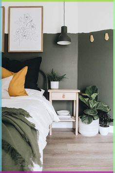 a bedroom with green walls and white bedding, potted plants on the nightstand