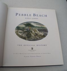 the book pebble beach golf links is open on a white surface with an image of a tree