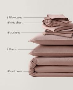 a stack of pillows and sheets with the names labelled in front of them on a white background