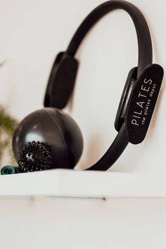 a pair of headphones sitting on top of a white shelf next to a plant