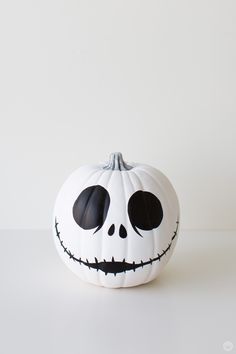 a white pumpkin with black eyes on it