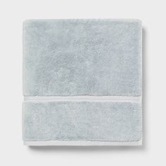 a light blue towel folded on top of a white wall