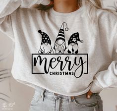 a woman wearing a merry christmas sweatshirt with gnomes and stars on the front in black